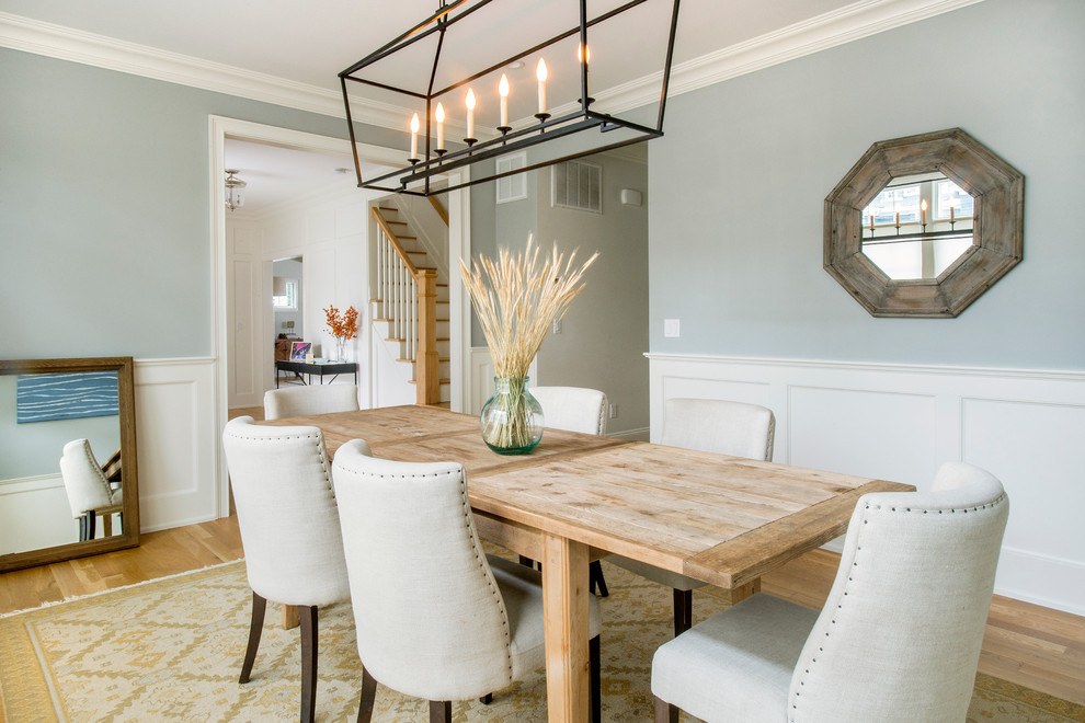 This is an example of a mid-sized transitional separate dining room in New York with grey walls and light hardwood floors.