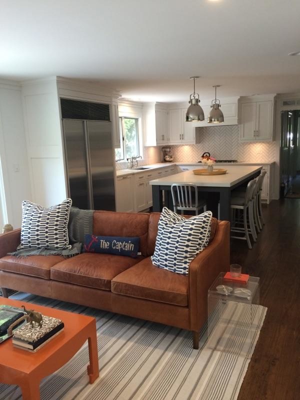 Mid-sized transitional l-shaped dark wood floor and brown floor open concept kitchen photo in New York with an undermount sink, shaker cabinets, white cabinets, limestone countertops, white backsplash, porcelain backsplash, stainless steel appliances and an island