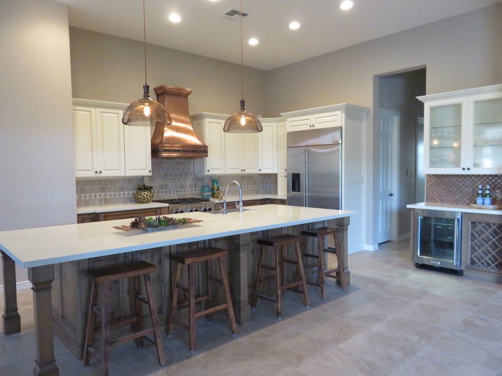 Inspiration for a large transitional porcelain tile open concept kitchen remodel in Phoenix with a farmhouse sink, raised-panel cabinets, distressed cabinets, quartz countertops, beige backsplash, stone tile backsplash, stainless steel appliances and an island