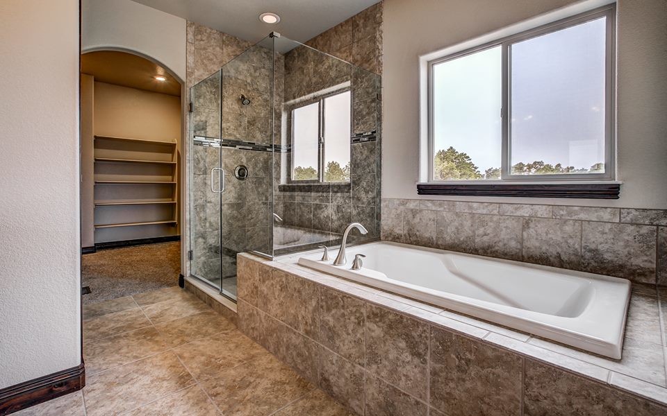 Inspiration for a large country master bathroom in Denver with a drop-in tub, an alcove shower, beige walls and ceramic floors.