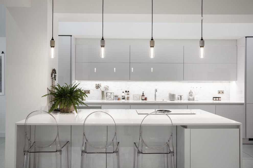 Inspiration for a large modern open plan kitchen in Essex with an undermount sink, white cabinets, quartzite benchtops, marble splashback, panelled appliances, porcelain floors, with island, white floor, flat-panel cabinets and white splashback.