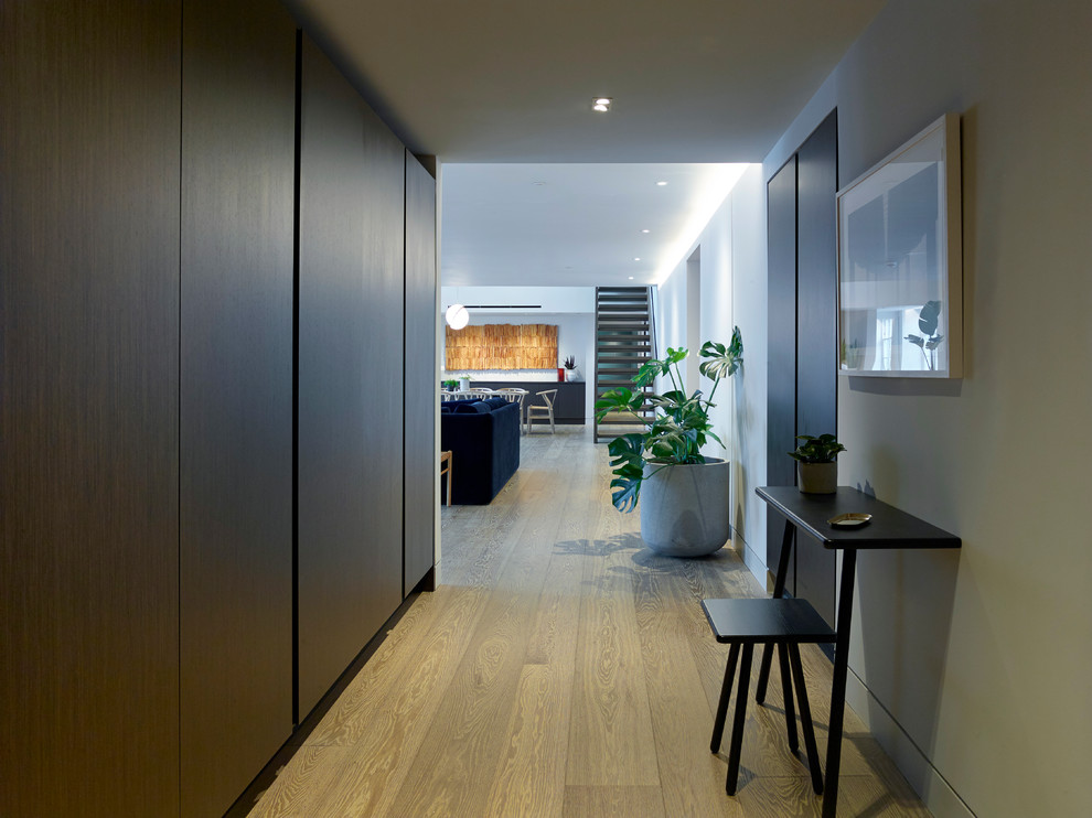 Mid-sized contemporary hallway in London with grey walls and light hardwood floors.