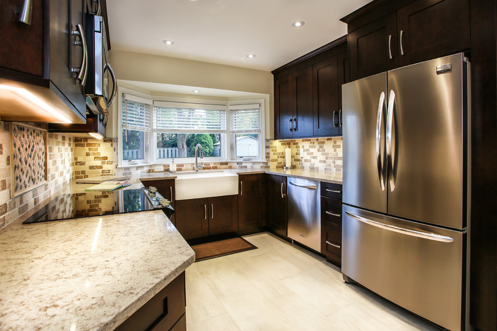 Example of a mid-sized transitional u-shaped porcelain tile enclosed kitchen design in Toronto with a farmhouse sink, shaker cabinets, dark wood cabinets, quartz countertops, beige backsplash, stone tile backsplash, stainless steel appliances and no island