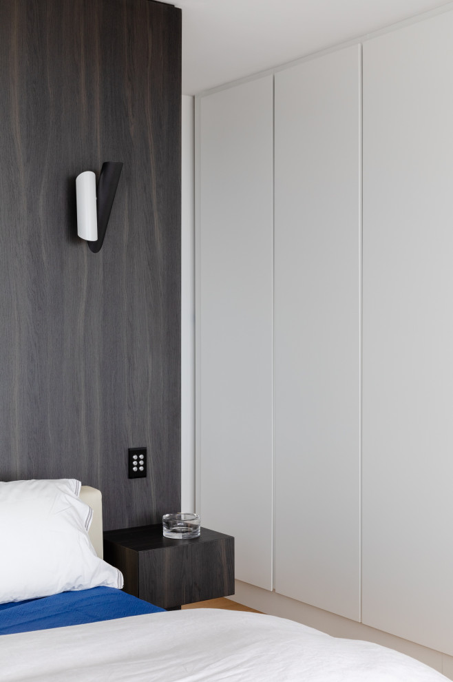 Esempio di una camera da letto contemporanea di medie dimensioni con pareti bianche, pavimento in legno massello medio, pavimento marrone e pareti in legno