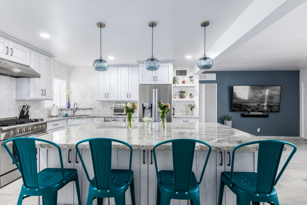 Kitchen - transitional l-shaped kitchen idea in Phoenix with a single-bowl sink, shaker cabinets, white cabinets, granite countertops, white backsplash and stainless steel appliances