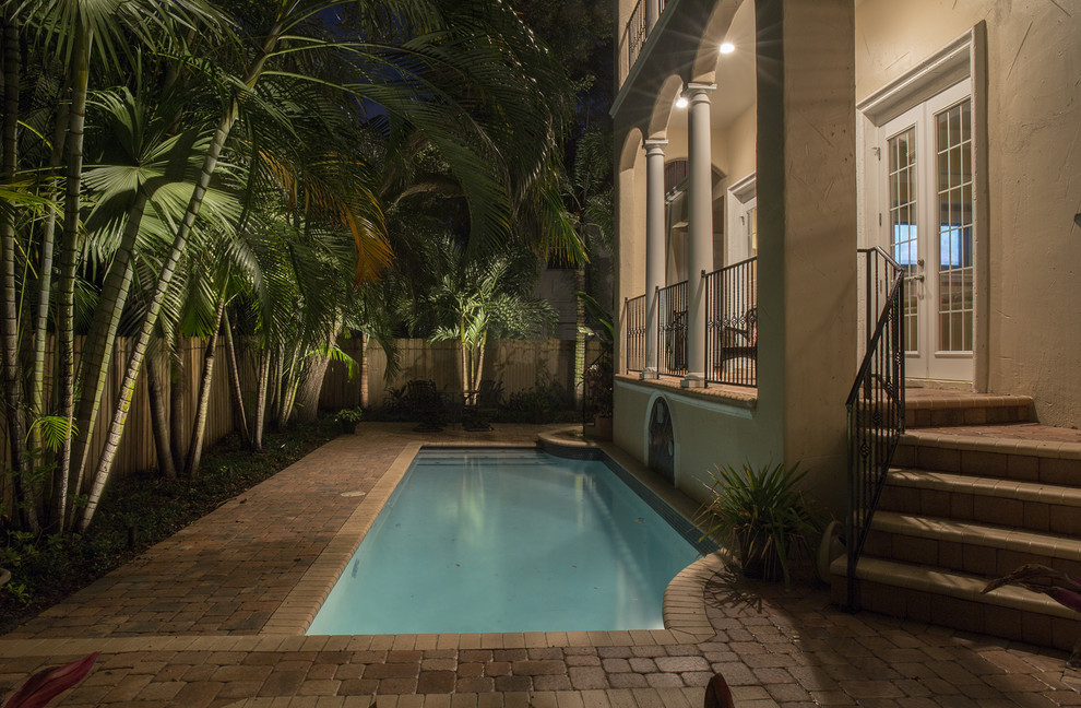 Small tropical backyard rectangular lap pool in Tampa with concrete pavers.