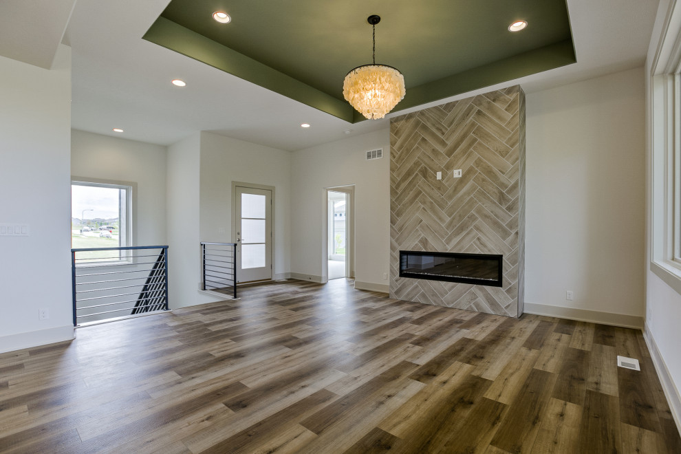 Photo of a modern formal open concept living room in Omaha with white walls, a ribbon fireplace, a tile fireplace surround, a wall-mounted tv and recessed.