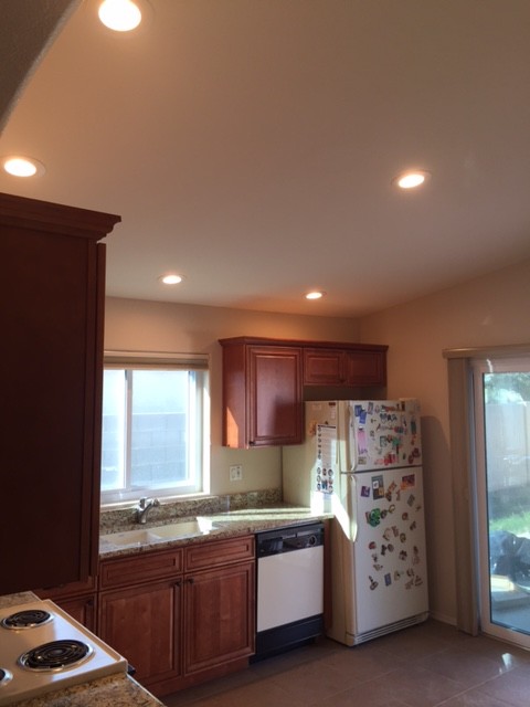 Eat-in kitchen - small transitional l-shaped ceramic tile eat-in kitchen idea in Phoenix with an undermount sink, raised-panel cabinets, medium tone wood cabinets, granite countertops, white appliances and no island