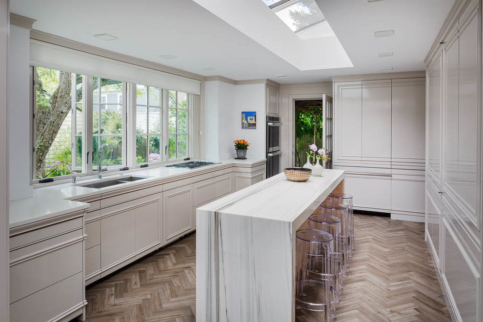 Photo of a large contemporary u-shaped separate kitchen in Boston with an undermount sink, flat-panel cabinets, white cabinets, quartz benchtops, white splashback, white appliances, medium hardwood floors and with island.