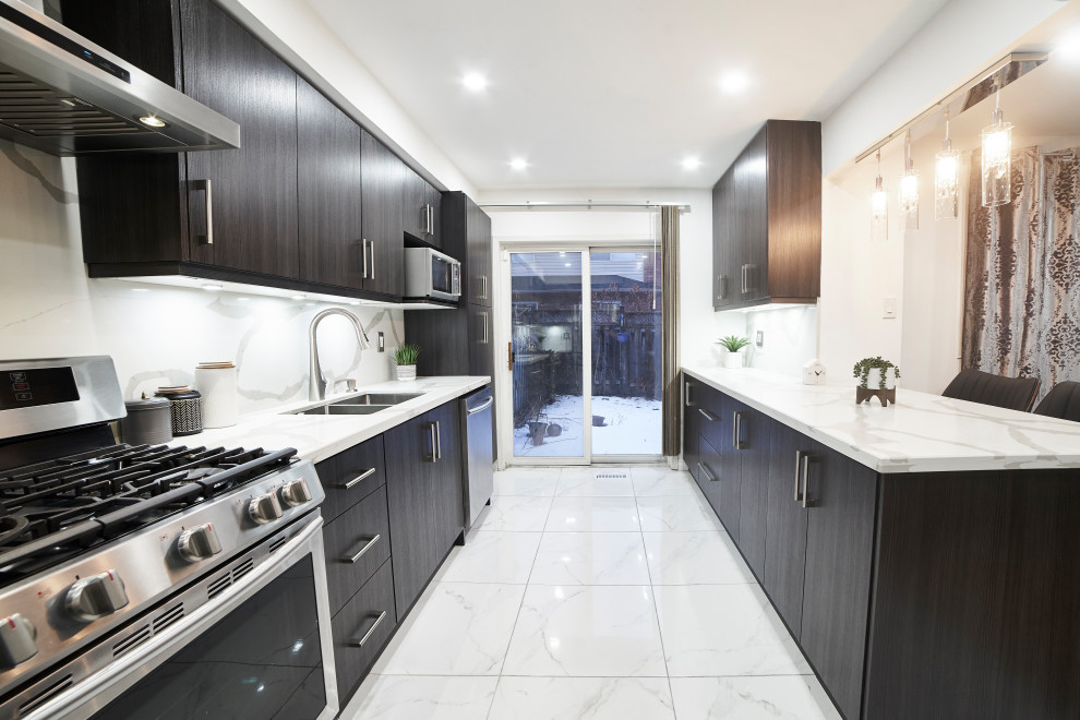 Foto på ett mellanstort funkis vit kök, med en dubbel diskho, släta luckor, bruna skåp, bänkskiva i kvarts, vitt stänkskydd, rostfria vitvaror, klinkergolv i porslin, en köksö och vitt golv
