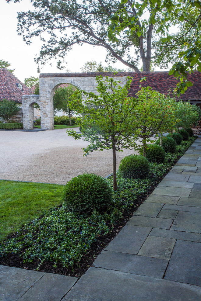 Design ideas for a large traditional partial sun formal garden for summer in Chicago with natural stone pavers.