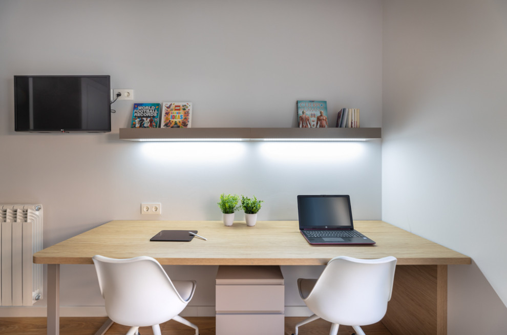 Cette image montre un petit bureau nordique avec un mur gris, un sol en bois brun, un bureau indépendant et un sol marron.