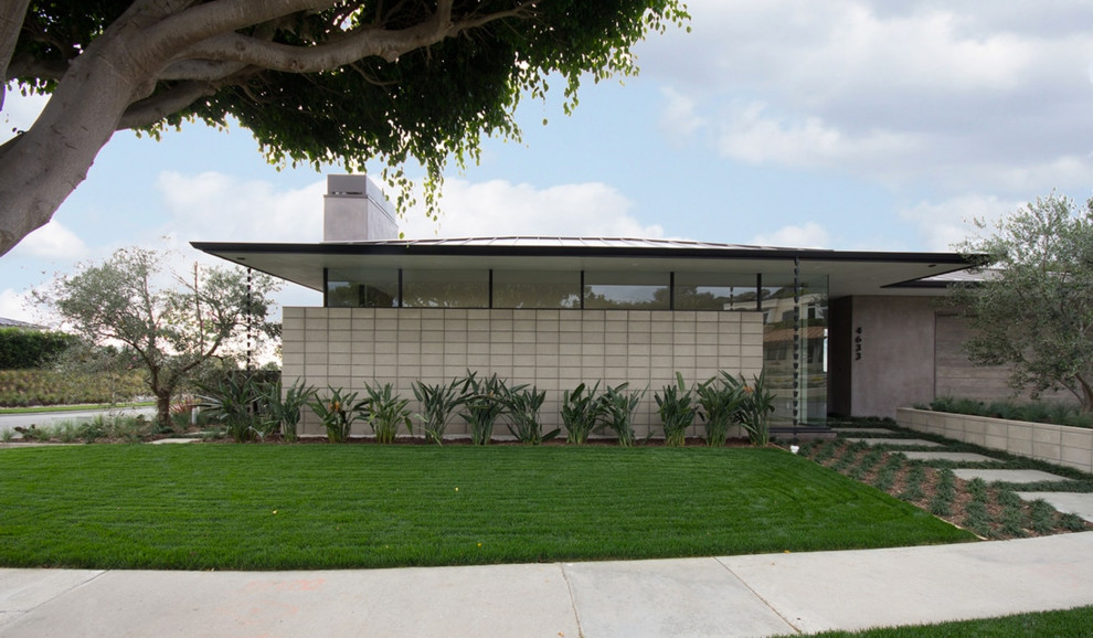 Design ideas for a midcentury one-storey concrete grey house exterior in Los Angeles with a hip roof and a metal roof.