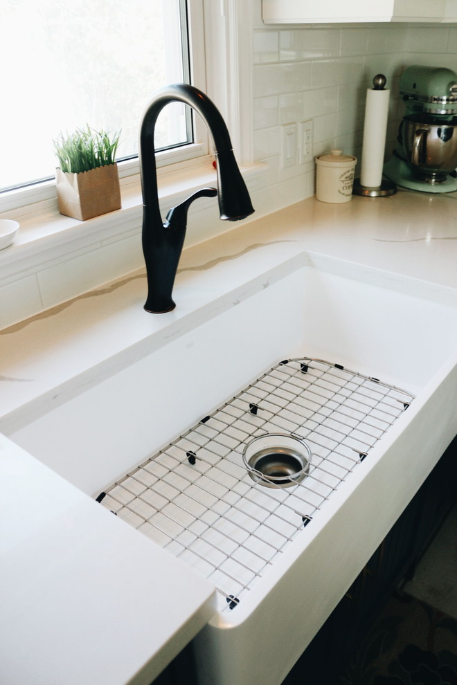 Home design - mid-sized transitional u-shaped porcelain tile and multicolored floor home design idea in Toronto with a farmhouse sink, beaded inset cabinets, blue cabinets, quartzite countertops, white backsplash, ceramic backsplash, stainless steel appliances, no island and multicolored countertops