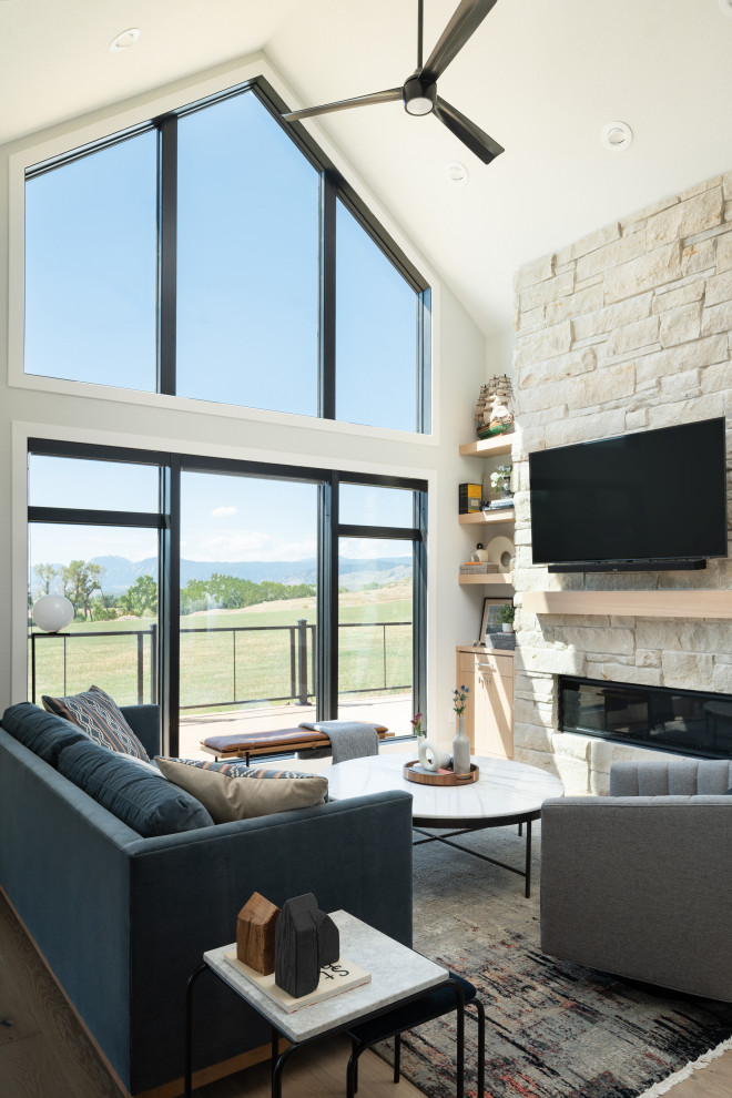 Пример оригинального дизайна: открытая гостиная комната в стиле модернизм с светлым паркетным полом, горизонтальным камином, фасадом камина из каменной кладки и телевизором на стене