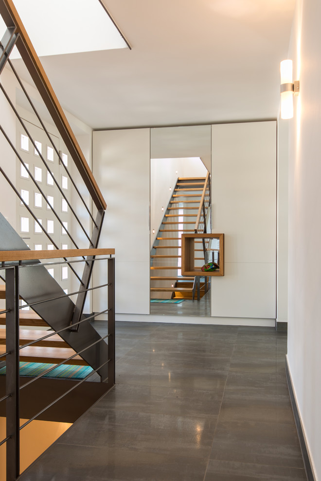 This is an example of a mid-sized contemporary wood straight staircase in Other with open risers.
