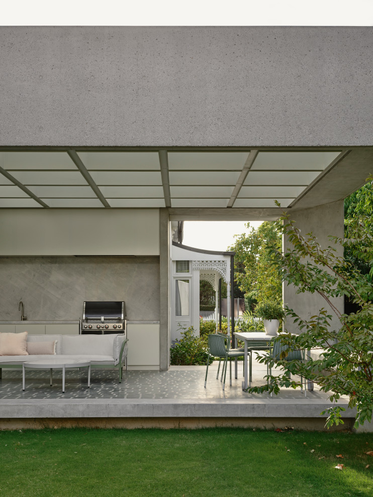 Photo of a mid-sized contemporary courtyard patio in Melbourne with an outdoor kitchen and a roof extension.