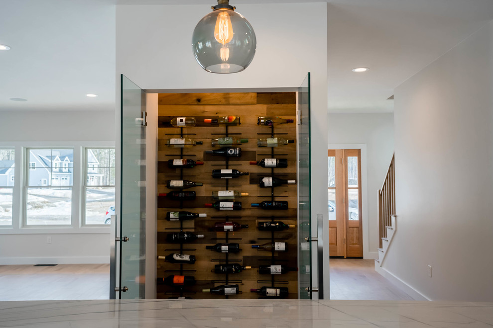 This is an example of a large country wine cellar in Other with light hardwood floors and brown floor.