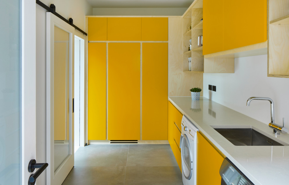 Inspiration for a contemporary laundry room in Cambridgeshire with flat-panel cabinets and yellow cabinets.