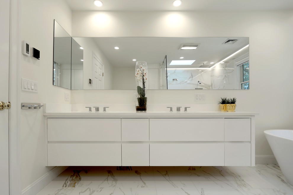 This is an example of a large contemporary master bathroom in Boston with an undermount sink, flat-panel cabinets, white cabinets, engineered quartz benchtops, a freestanding tub, an open shower, white tile, porcelain tile, white walls and porcelain floors.