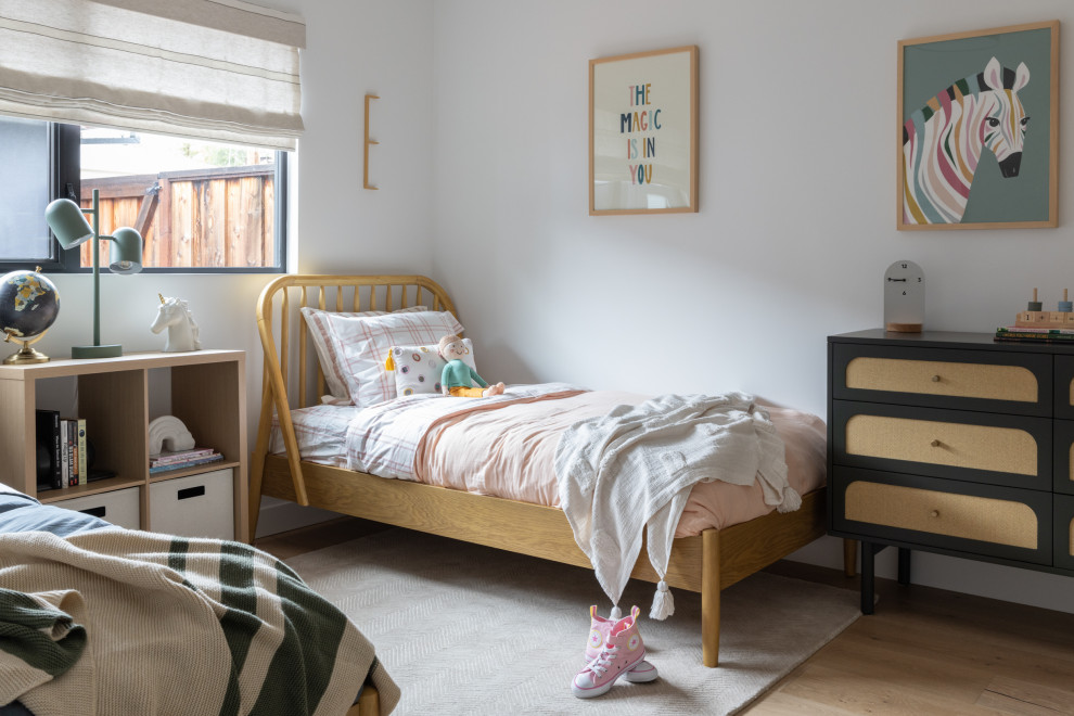 Transitional kids' bedroom in San Francisco with white walls, medium hardwood floors and brown floor for girls.