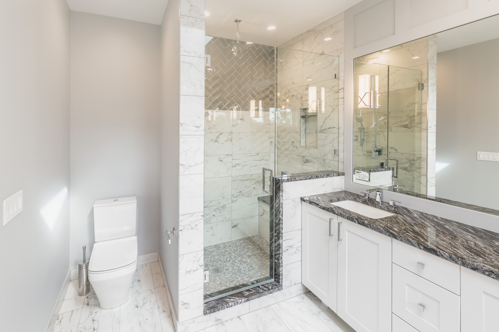 This is an example of a mid-sized transitional master bathroom in Chicago with white cabinets, a freestanding tub, an open shower, a one-piece toilet, white walls, marble floors, a drop-in sink, white floor, a hinged shower door, grey benchtops, a double vanity and a freestanding vanity.