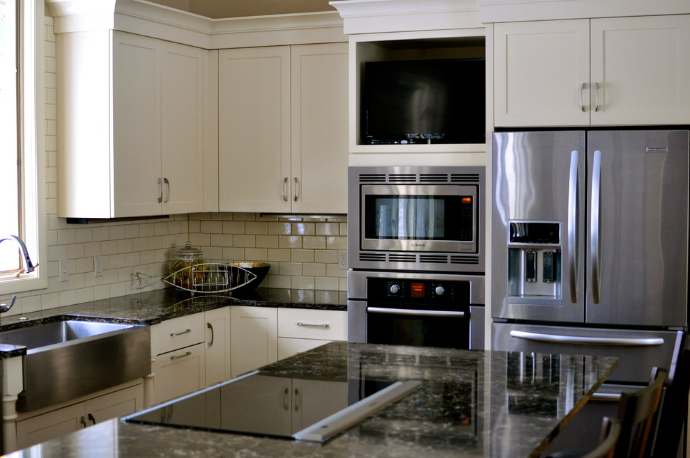 Eat-in kitchen - transitional l-shaped eat-in kitchen idea in Grand Rapids with a farmhouse sink, shaker cabinets, quartz countertops, ceramic backsplash and stainless steel appliances