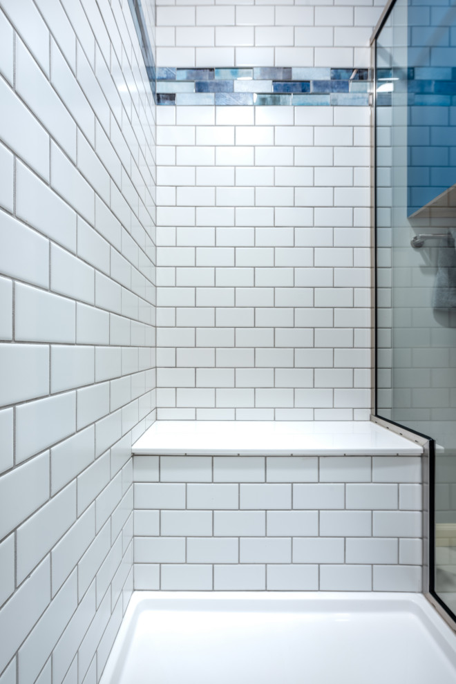 Inredning av ett klassiskt litet grå grått badrum med dusch, med blå skåp, en dusch i en alkov, en toalettstol med separat cisternkåpa, vit kakel, tunnelbanekakel, grå väggar, vinylgolv, ett integrerad handfat, bänkskiva i onyx, vitt golv och dusch med skjutdörr