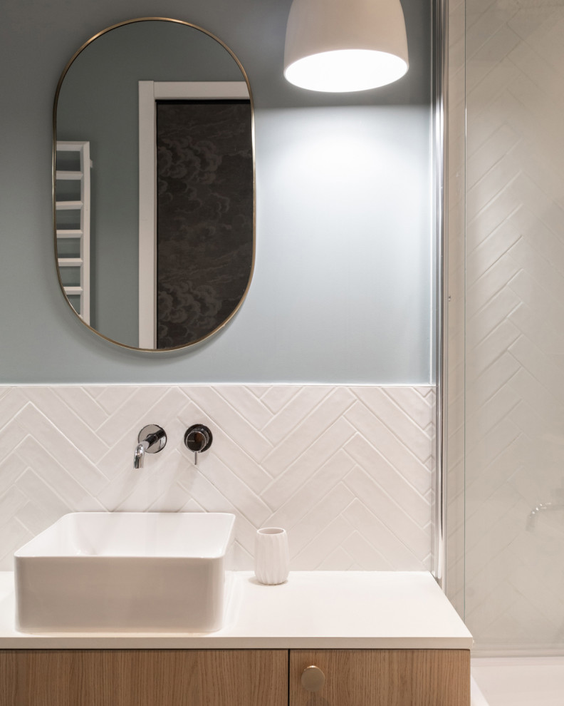 This is an example of a mid-sized contemporary kids bathroom in Paris with beaded inset cabinets, light wood cabinets, an undermount tub, white tile, ceramic tile, white walls, ceramic floors, a drop-in sink, laminate benchtops, blue floor, white benchtops, a niche, a double vanity and a built-in vanity.