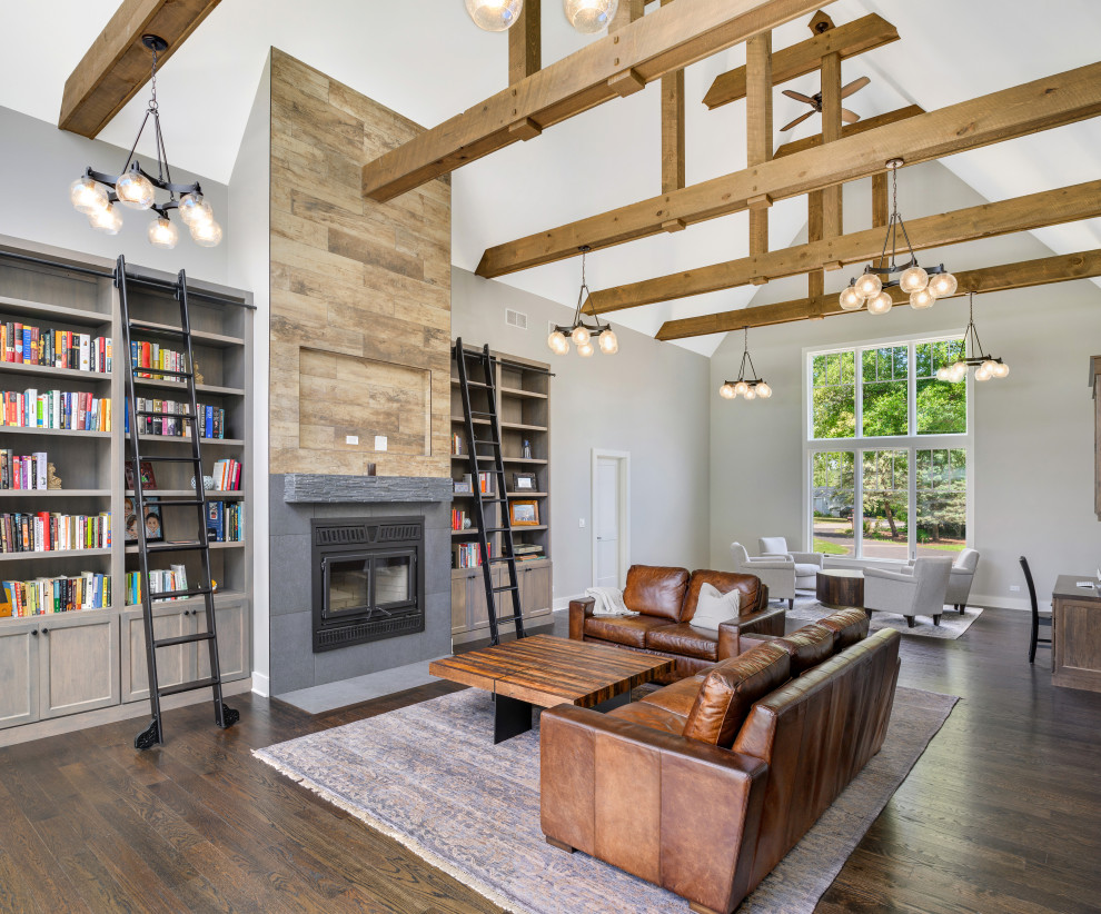 Photo of a transitional open concept family room in Chicago with grey walls, medium hardwood floors, a wood stove, a wall-mounted tv and brown floor.