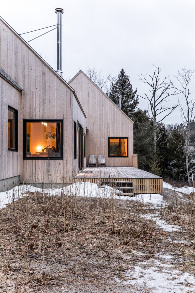 Стильный дизайн: одноэтажный, деревянный частный загородный дом среднего размера в скандинавском стиле с крышей из гибкой черепицы и черной крышей - последний тренд