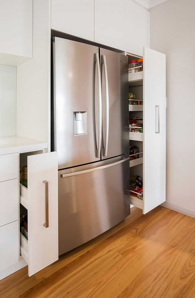 This is an example of a mid-sized beach style open plan kitchen in Sydney with stainless steel appliances and with island.