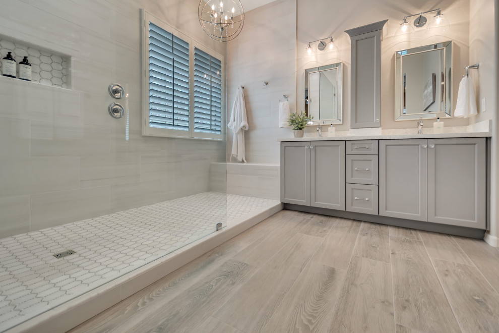 Mid-sized transitional master white tile and porcelain tile wood-look tile floor, multicolored floor and double-sink doorless shower photo in Phoenix with shaker cabinets, gray cabinets, gray walls, an undermount sink, granite countertops, white countertops and a niche