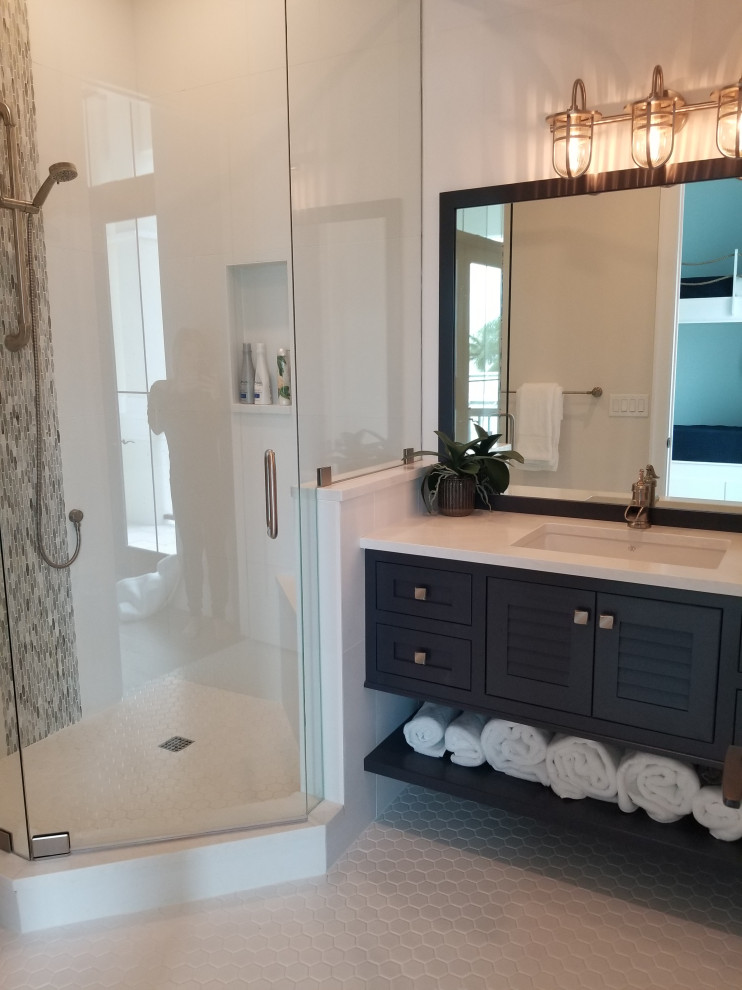 Mid-sized transitional kids bathroom in Miami with louvered cabinets, blue cabinets, an alcove shower, a two-piece toilet, white tile, porcelain tile, beige walls, porcelain floors, an undermount sink, engineered quartz benchtops, white floor, a hinged shower door and white benchtops.