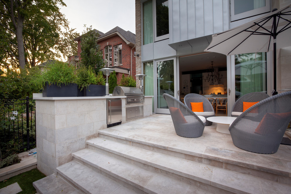 Foto di un piccolo patio o portico design dietro casa con pavimentazioni in pietra naturale e nessuna copertura