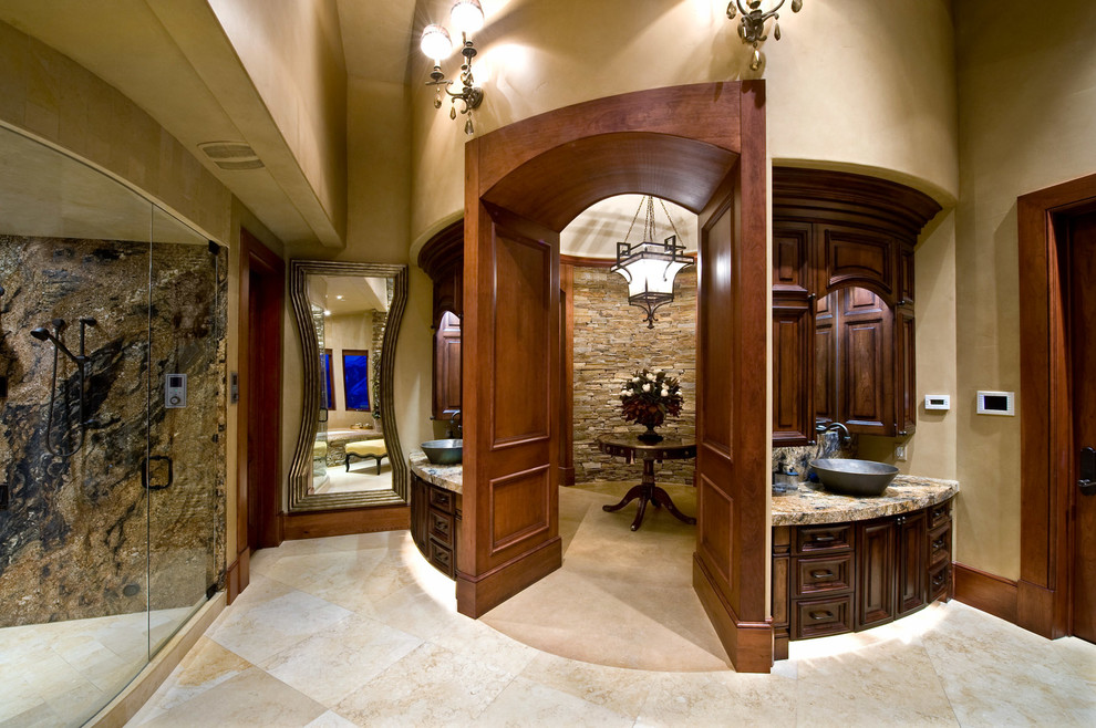 Inspiration for an expansive arts and crafts master bathroom in Salt Lake City with raised-panel cabinets, dark wood cabinets, an undermount tub, beige walls, travertine floors, a vessel sink, granite benchtops, a corner shower, beige tile and stone tile.