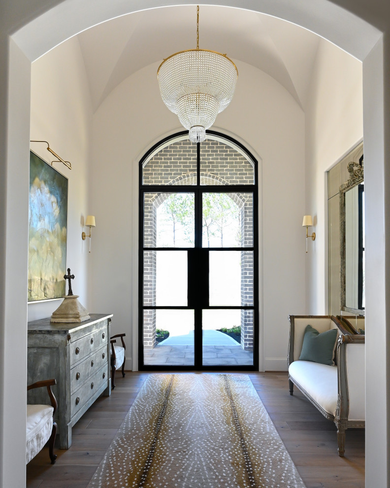 Ejemplo de puerta principal abovedada de tamaño medio con paredes blancas, suelo de madera oscura, puerta doble y puerta negra
