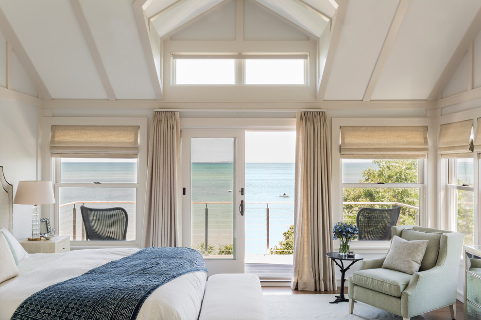 Inspiration for a beach style master bedroom in Boston with white walls and medium hardwood floors.