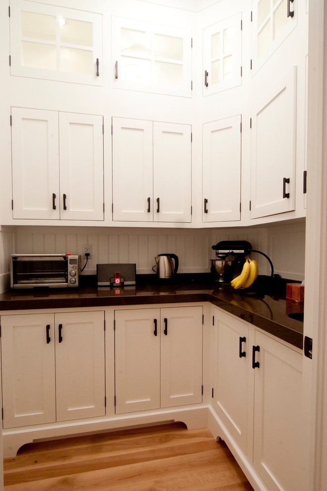 Photo of a small traditional l-shaped kitchen pantry in Ottawa with an undermount sink, shaker cabinets, white cabinets, granite benchtops, white splashback, timber splashback, light hardwood floors, no island and multi-coloured floor.