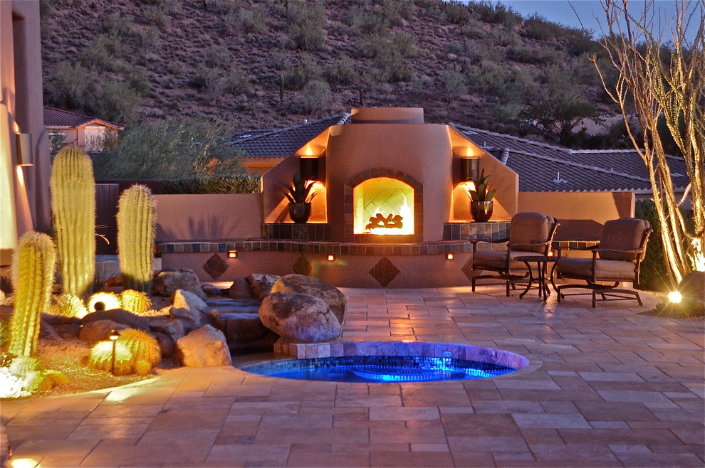 Photo of a large backyard patio in Phoenix with a fire feature, concrete pavers and no cover.