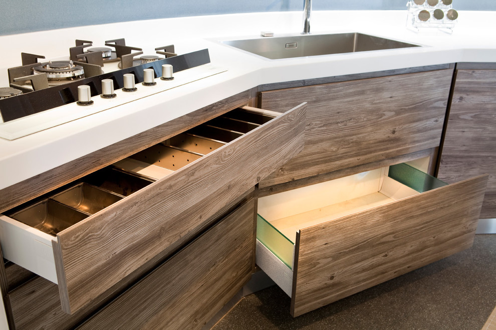 This is an example of a contemporary kitchen in Milan with a drop-in sink, glass-front cabinets and medium wood cabinets.