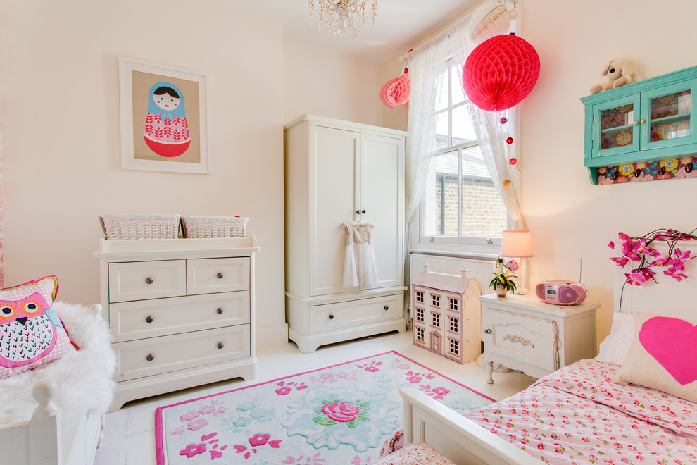 Design ideas for a mid-sized eclectic kids' bedroom for kids 4-10 years old and girls in London with pink walls, painted wood floors and white floor.