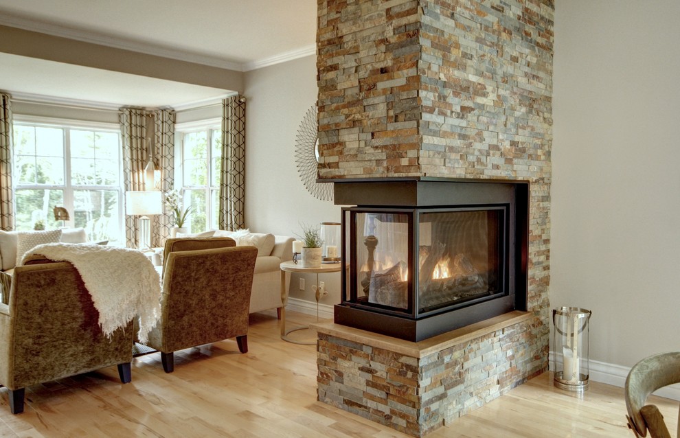 Enclosed dining room - mid-sized transitional light wood floor and brown floor enclosed dining room idea with gray walls, a two-sided fireplace and a stone fireplace