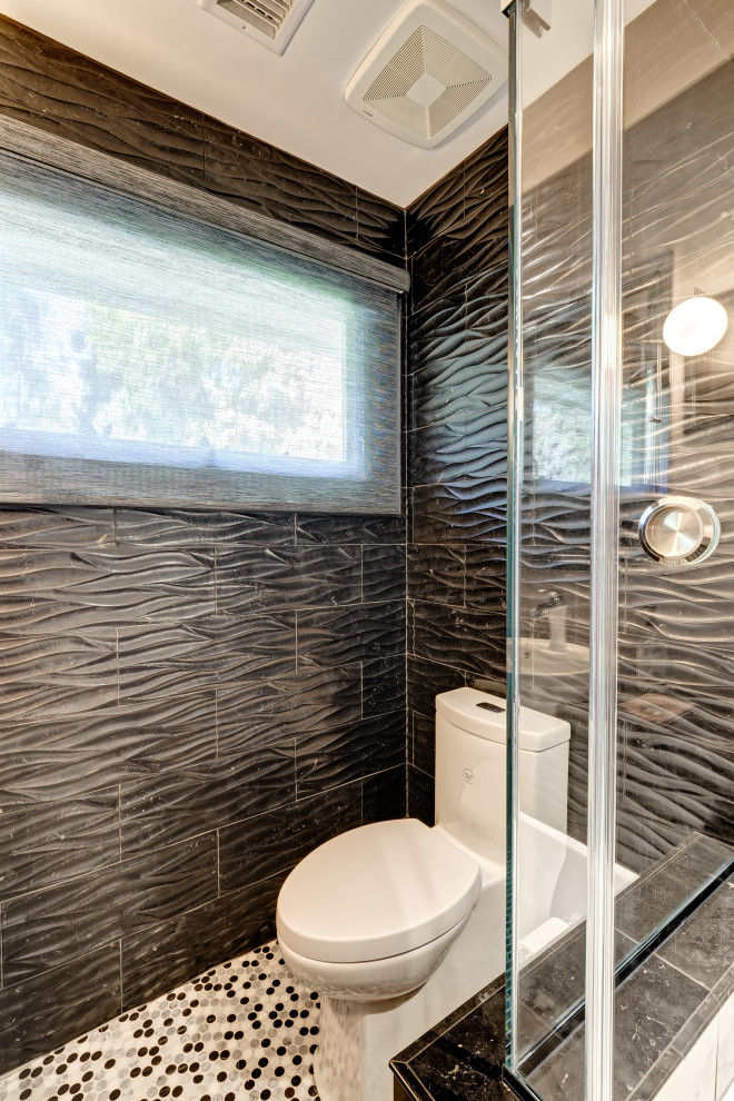 На фото: маленькая ванная комната в стиле модернизм с плоскими фасадами, серыми фасадами, угловой ванной, душем над ванной, унитазом-моноблоком, черной плиткой, керамогранитной плиткой, серыми стенами, полом из мозаичной плитки, душевой кабиной, накладной раковиной, столешницей из искусственного кварца, разноцветным полом, душем с раздвижными дверями, черной столешницей, тумбой под одну раковину и встроенной тумбой для на участке и в саду