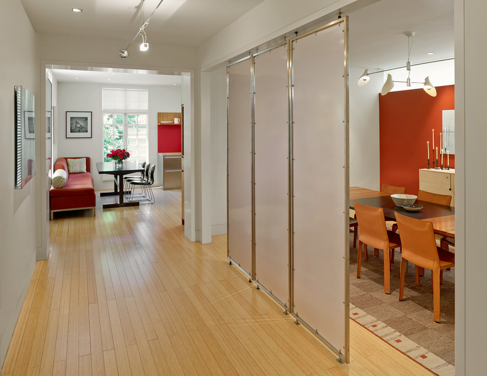This is an example of a large contemporary hallway in San Francisco with white walls and light hardwood floors.