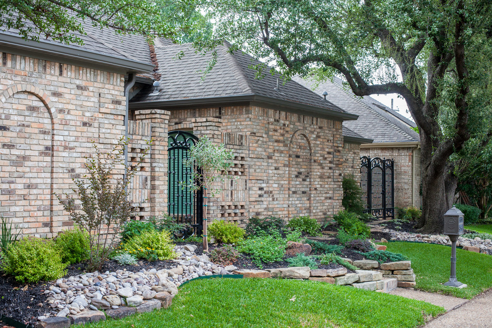 This is an example of a mid-sized eclectic front yard full sun xeriscape in Dallas with a garden path and natural stone pavers.