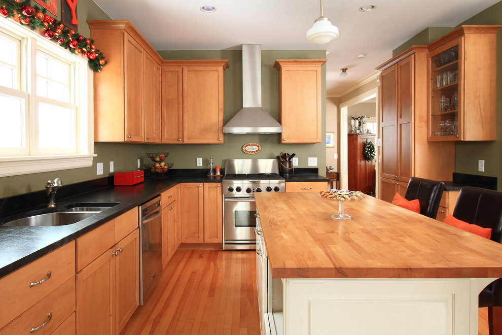 This is an example of a country kitchen in Minneapolis with stainless steel appliances and wood benchtops.