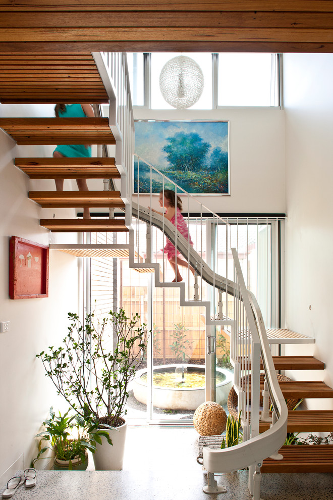 Photo of a contemporary wood u-shaped staircase in Canberra - Queanbeyan with open risers.
