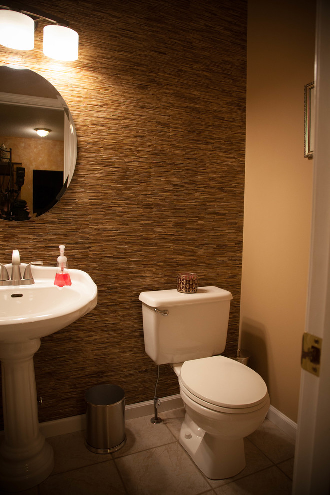 Photo of a small transitional powder room in St Louis with a two-piece toilet, beige tile, glass tile, beige walls, ceramic floors, a pedestal sink and solid surface benchtops.