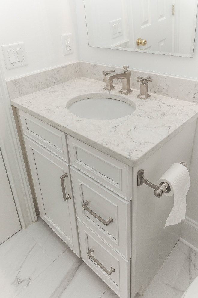 Design ideas for an expansive contemporary master bathroom in Atlanta with recessed-panel cabinets, white cabinets, a freestanding tub, a two-piece toilet, white tile, marble, white walls, porcelain floors, an undermount sink, engineered quartz benchtops and white floor.